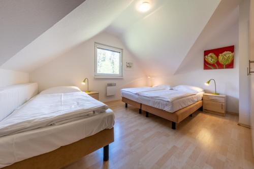 two beds in a room with a attic at Villa Gamma - Lipno Home in Lipno nad Vltavou