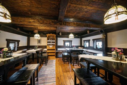 a restaurant with wooden ceilings and tables and chairs at Pension La Roata in Gura Humorului
