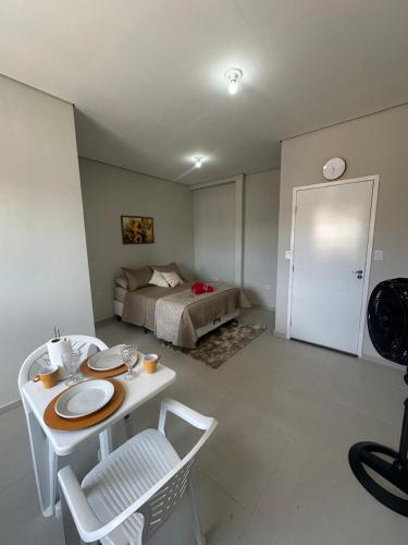 a room with a bed and a table and chairs at 05 Studios centro,proximo a rodoviaria-itapeva sp in Itapeva