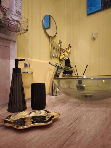 a bathroom with a glass sink and a mirror at Station and Border Comfort Art and Cats Inn - Комфорт у вокзала и границы Арт и Кот in Narva