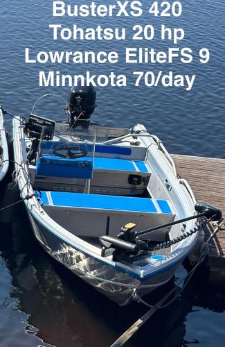 a boat docked at a dock in the water at Villa Joutsen with jacuzzi in Vuoriniemi