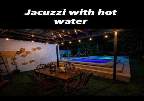 a table and chairs in a backyard with a swimming pool at Amancay House, Jacuzzi and Pool in San Cristóbal