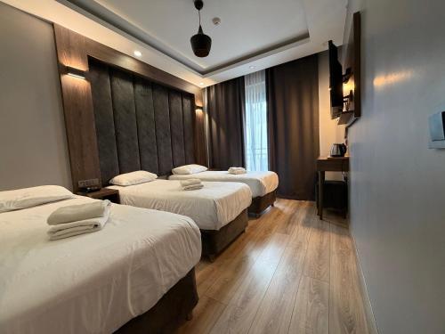 a hotel room with three beds and a window at The Basilissis Gulhane in Istanbul