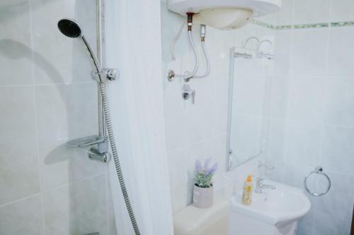 a white bathroom with a shower and a sink at Apartmants Bubalo in Trpanj