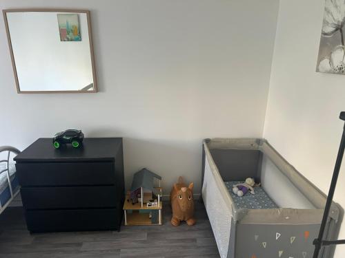 a bedroom with a bed and a dresser and a crib at Family House in Beauvais