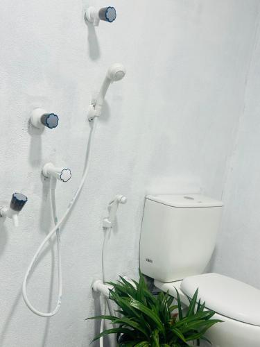 a white bathroom with a toilet and a shower at Moonlight Villa in Pottuvil