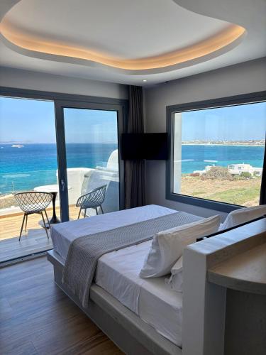 a bedroom with a large bed with a view of the ocean at DIA suites collection in Mikri Vigla