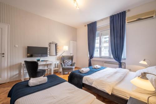 a hotel room with two beds and a desk at Selection Rooms in Belgrade