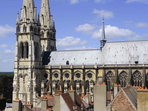 a large cathedral with a tower and a building at ibis Moulins in Moulins