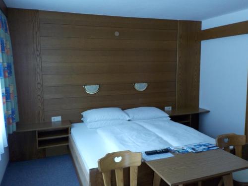 レンゲンフェルトにあるGästehaus Kuenのベッドルーム1室(大型ベッド1台、木製ヘッドボード付)