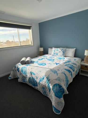 a bedroom with a bed with a quilt and a window at Old Pier Apartments in Bridport