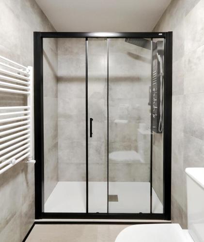 a shower in a bathroom with a glass door at Luxury apartamento Muralla de Lugo 1.2 in Lugo