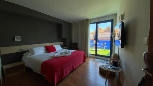 a hotel room with a bed and a large window at Hotel Cal Tet in L'Estartit