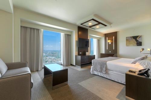 a hotel room with a bed and a couch at Riu Plaza Guadalajara in Guadalajara