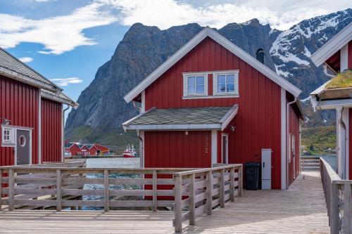 a red house with a mountain in the background at Reine seaview cabin in Reine