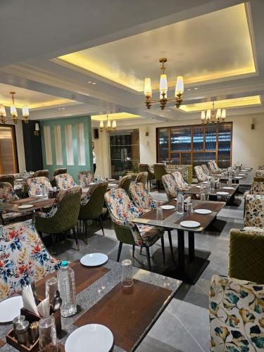 a restaurant with couches and tables and chairs at Hotelyashraj in Pipra Dewās