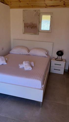 a bedroom with a large white bed with two pillows at Charming Village Farmhouse, Çukë in Sarandë
