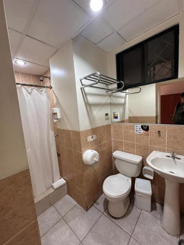 a bathroom with a toilet and a sink at Hotel Las Peñas in Guayaquil