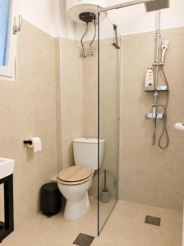 a bathroom with a toilet and a shower stall at Tolo at sea - Emma in Tolo