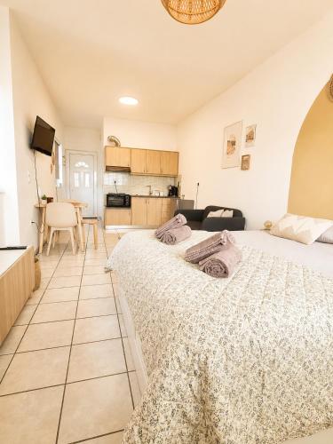 a bedroom with a large bed and a kitchen at Tolo at sea - Emma in Tolo