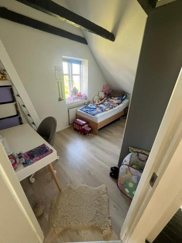 an attic room with a bed and a desk at patriciervilla i 2plan udlejes in Hjørring