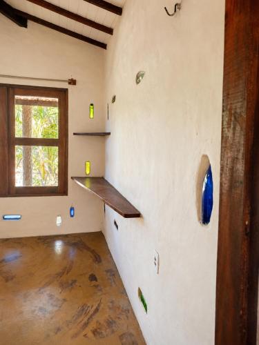 a room with a wall with a shelf and a window at Casa do Parcerito in Cajueiro