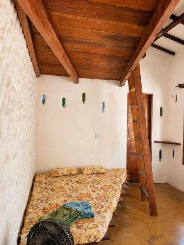 a bed in a room with a wooden ceiling at Casa do Parcerito in Cajueiro