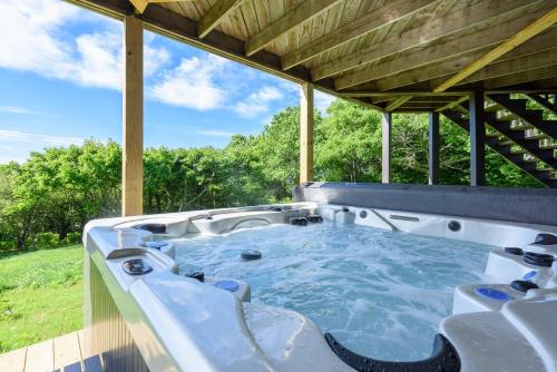 a jacuzzi tub on the back of a house at Elderberry Escape in Beech Mountain