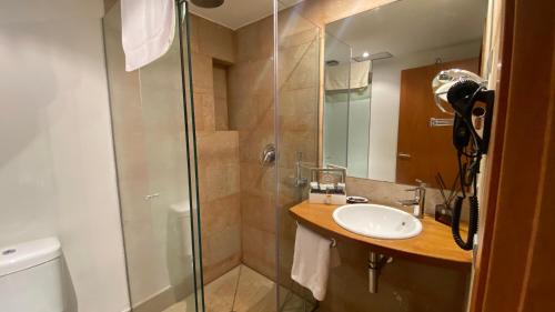 a bathroom with a shower and a sink and a toilet at Hotel Cal Tet in L'Estartit