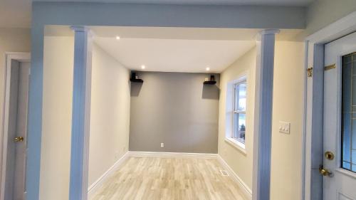 an empty hallway with blue and white walls and a window at House - Bungalow in Hamilton