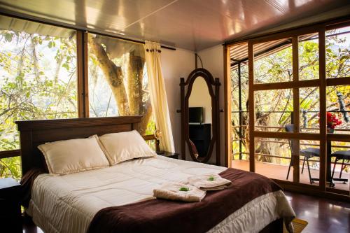 a bedroom with a bed with two towels on it at Hotel Campestre Rocas Del Paraíso in Machetá