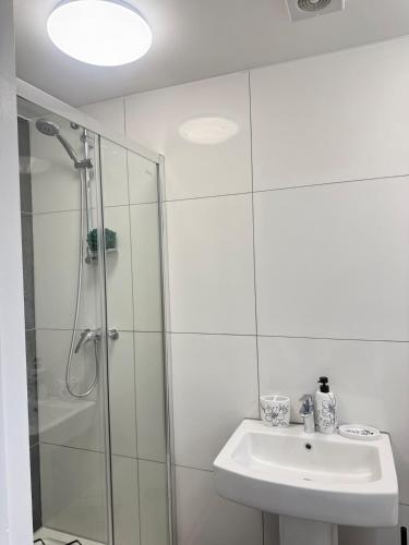 a white bathroom with a shower and a sink at One Bedroom Luxurious Flat - Free Parking in Rochester