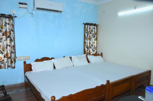 a bedroom with a large white bed in a room at jayaram Home Palace Chittoor in Chittoor
