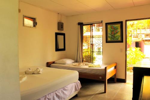 a room with two beds and a window at The Landing Hotel And Restaurant in Moyogalpa