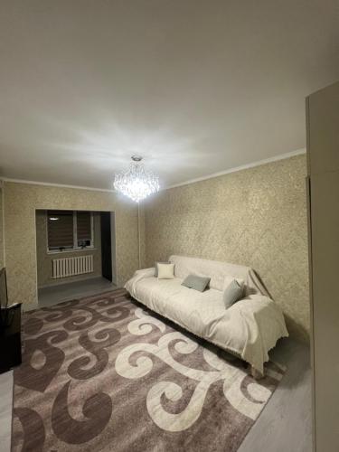 a bedroom with a large bed and a chandelier at Уют как дома in Shymkent