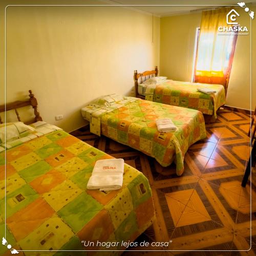 a room with three beds in a room at Chaska Backpackers & Rooms in Ayacucho