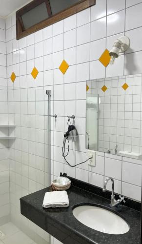 a bathroom with a sink and a mirror at Mariá Plaza Hotel in Araçatuba