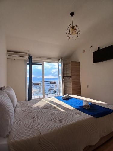 a bedroom with a large bed with a view of the ocean at Lake Breeze Aparments - Trpejca in Trpejca