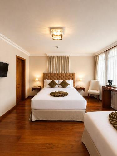 a bedroom with a large white bed and a chair at Dakani Hotel Boutique NEW in Quito