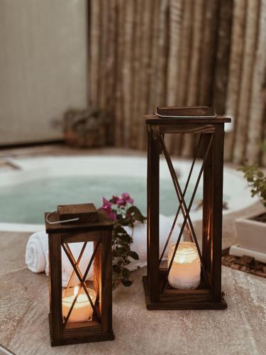 two wooden candles sitting next to a bath tub at Statera Host - Pousada de Bem-Estar in Alto Paraíso de Goiás