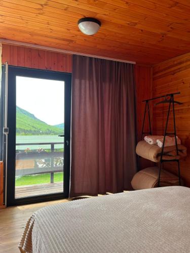 a bedroom with a bed and a large window at Guesthouse Driti in Shkodër