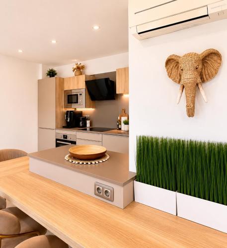 a kitchen with a table with an elephant head on the wall at Loft Marina in Cogolin