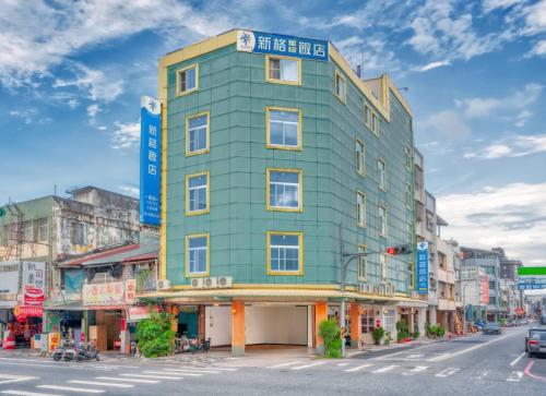 a green building on the corner of a street at 花蓮市區新格大飯店-部分房型 保證車位 Hualien Synco Hotel in Hualien City