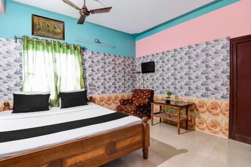 a bedroom with a bed and a chair at Hotel O Green House in Lālbāgh