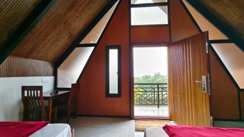 a room with a wooden door and a balcony at Vaango Cottages in Idukki