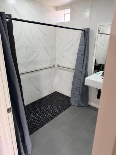 a bathroom with a shower and a sink at Rocky Inn Motel in Lynwood