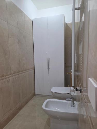 a white bathroom with a toilet and a sink at Erminia Apartaments in Vico Equense