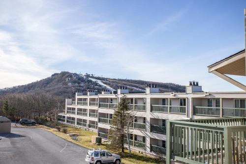 an apartment building with a mountain in the background at Condo at Pinnacle Inn Resort in Beech Mountain