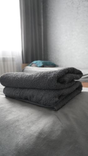 a pile of towels sitting on top of a bed at Dan plus in Aktobe