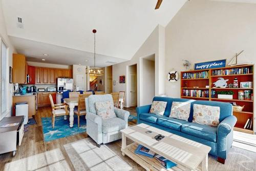a living room with a blue couch and a table at Bear Trap Dunes - 81 Tulip Poplar in Ocean View